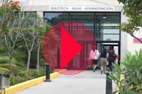 Foto del acceso al edificio de Veterinaria. Sobre la misma, un icono botón de reproducción de vídeo