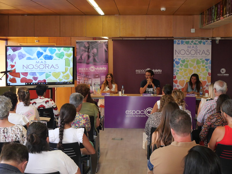 Tres personas sentadas en la mesa central