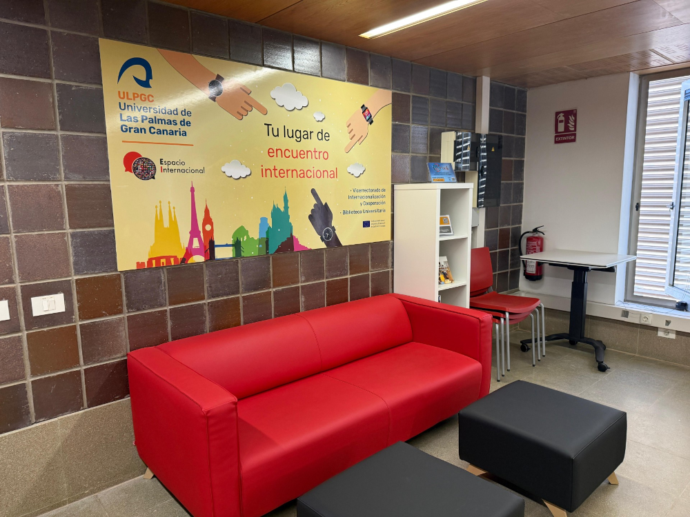Mesas y sillas en sala de biblioteca con sofá