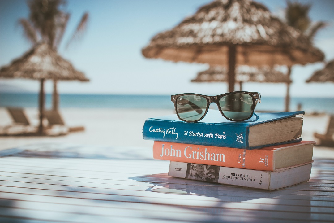 Libros, tumbona y sombrillas en una playa