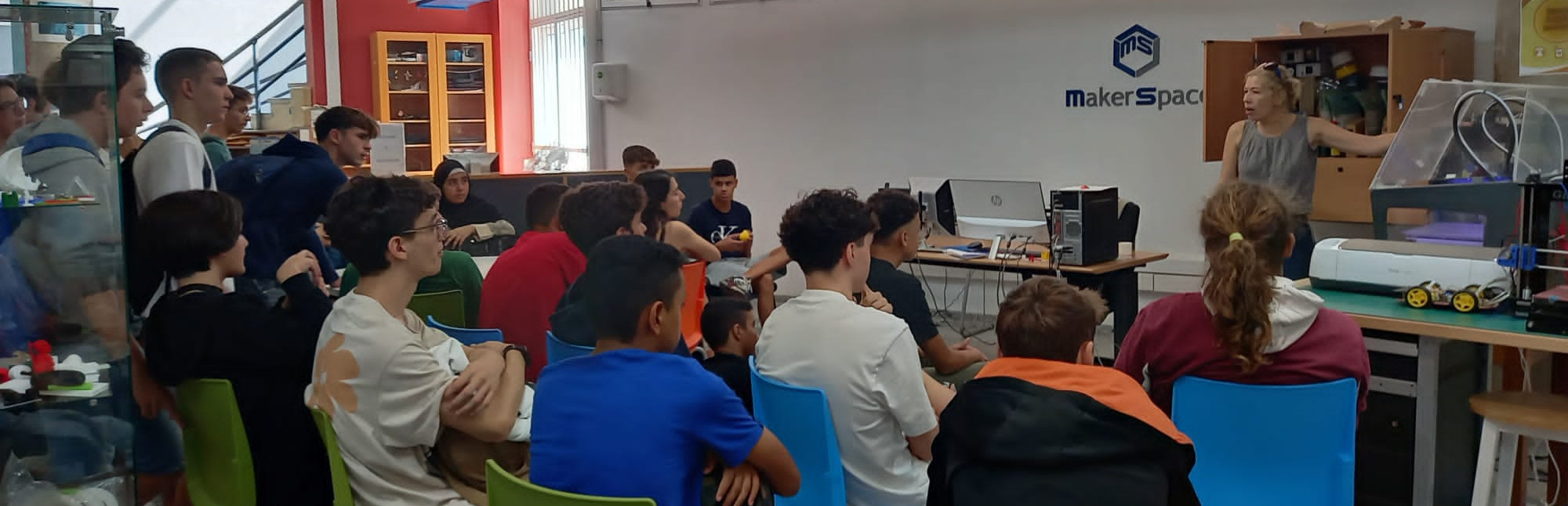 Un grupo de estudiantes atiende la presentación del servicio de impresión 3D a cargo de una bibliotecaria