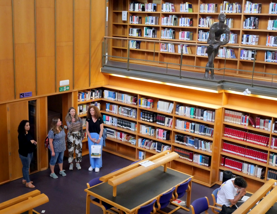 vista cenital de 4 personas en sala de biblioteca de tres pisos