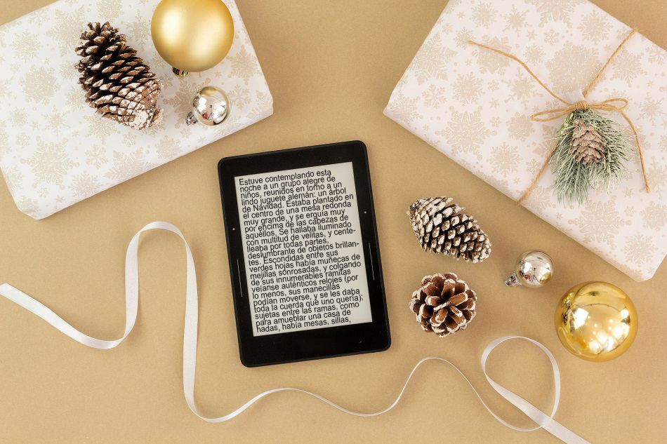 Lector de libros electrónicos rodeado de decoración y motivos navideños