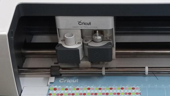 Vista de la parte frontal de la cortadora con el cabezal con el texto Cricut: adaptative tool system.