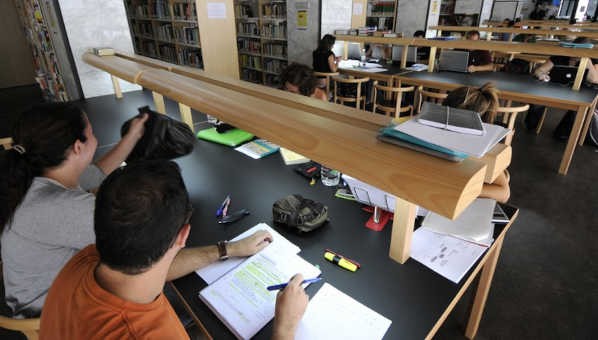 Vista de estudiantes en mesas de estudio con apuntes en la sala de estudios de la biblioteca del Obelisco