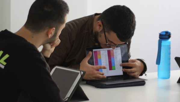 Estudiante mostrado gráficos en un ordenador a sus compañeros y compañera