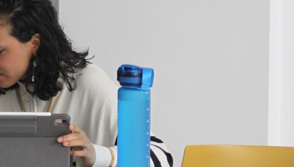Estudiante sentada con tablet y botella de agua
