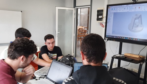 Cuatro alumnos sentados alrededor de una mesa en una sala de trabajo colaborativo de la biblioteca de Ingenierías