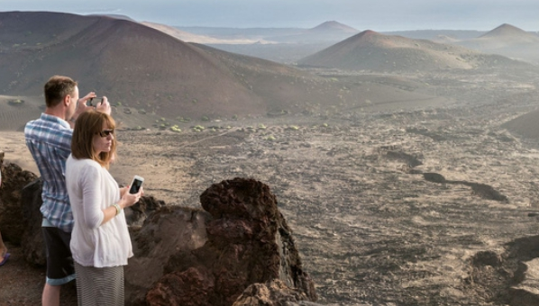 Paisaje volcánico de Lanzarote con una pareja de visitantes