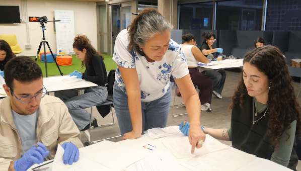 Personas trabajando sobre un libro antiguo abierto