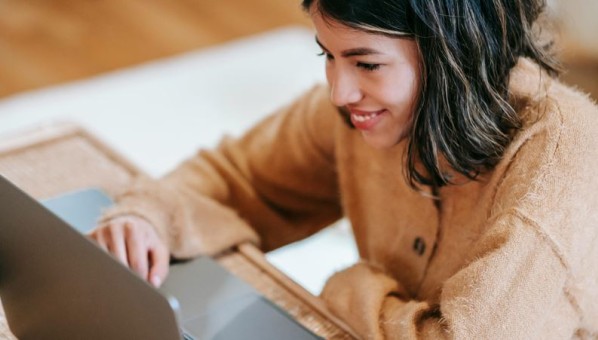 Mujer adolescente tecleando un ordenador portátil 