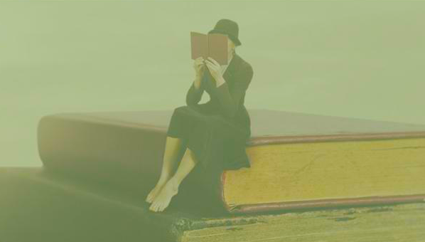 Composición fotográfica con una mujer con traje de chaqueta, falda y sombrero, que lee un libro sentada sobre una pila de libros sobredimensionados.