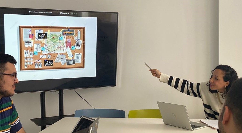 Espacios de trabajo colaborativo Estudiante señalando la pizarra digital a sus dos compañeros