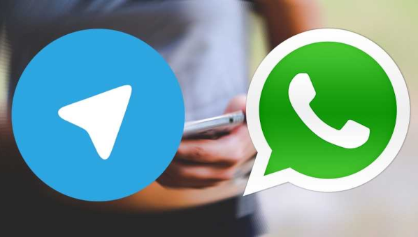 Logos de Telegram y WhatsApp sobre fotografía difusa de persona con teléfono móvil en la mano.