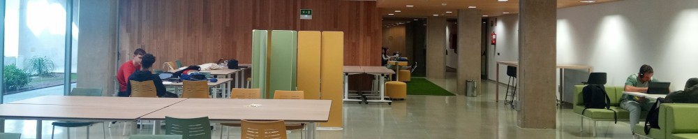 Vista de varios grupos de estudiantes en mesas y sofás en una sala de biblioteca con mobiliario funcional y polivalente.